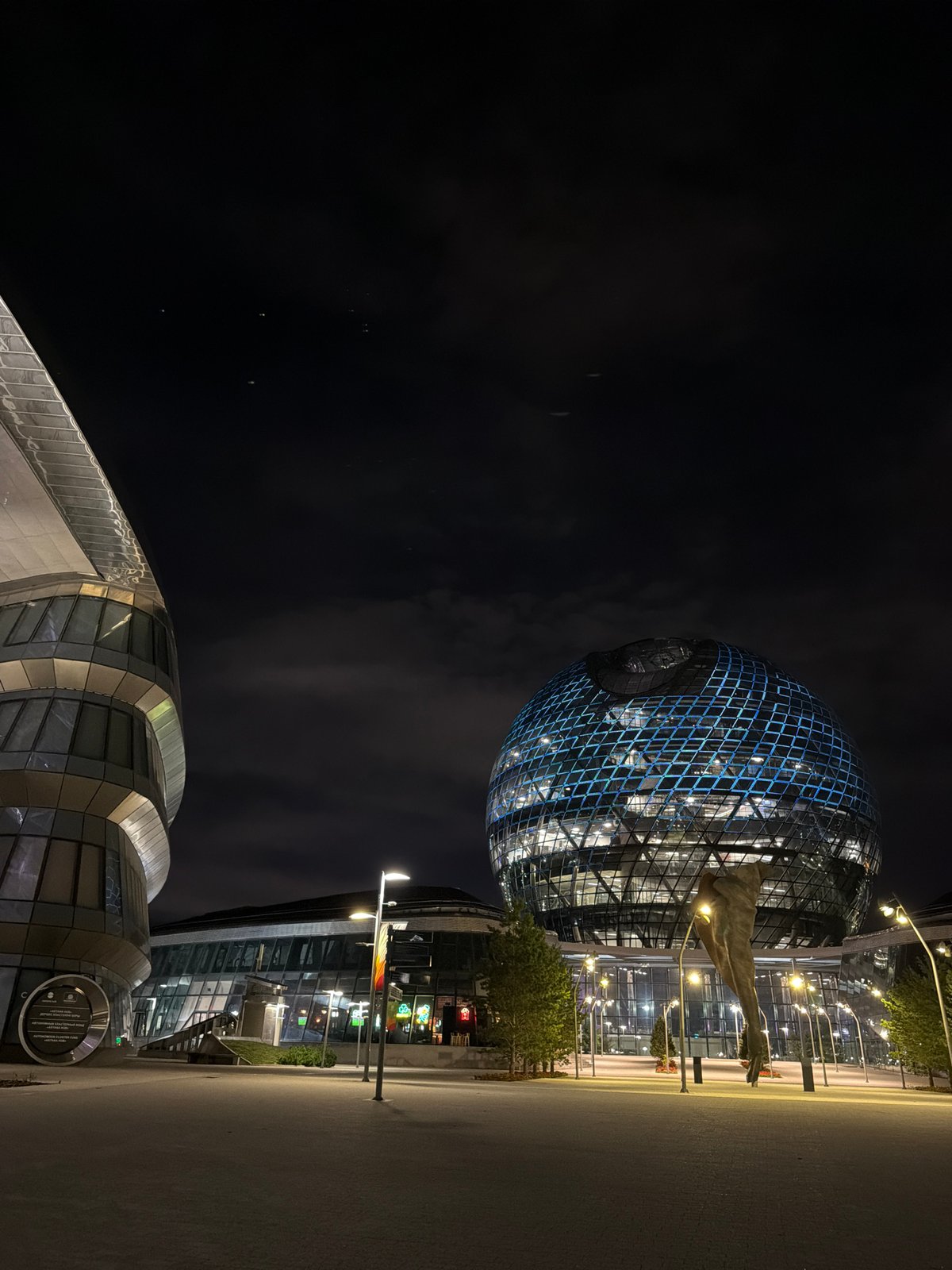 Astana at night: Nur Alem sphere, plaza sculpture, and crescent moon
