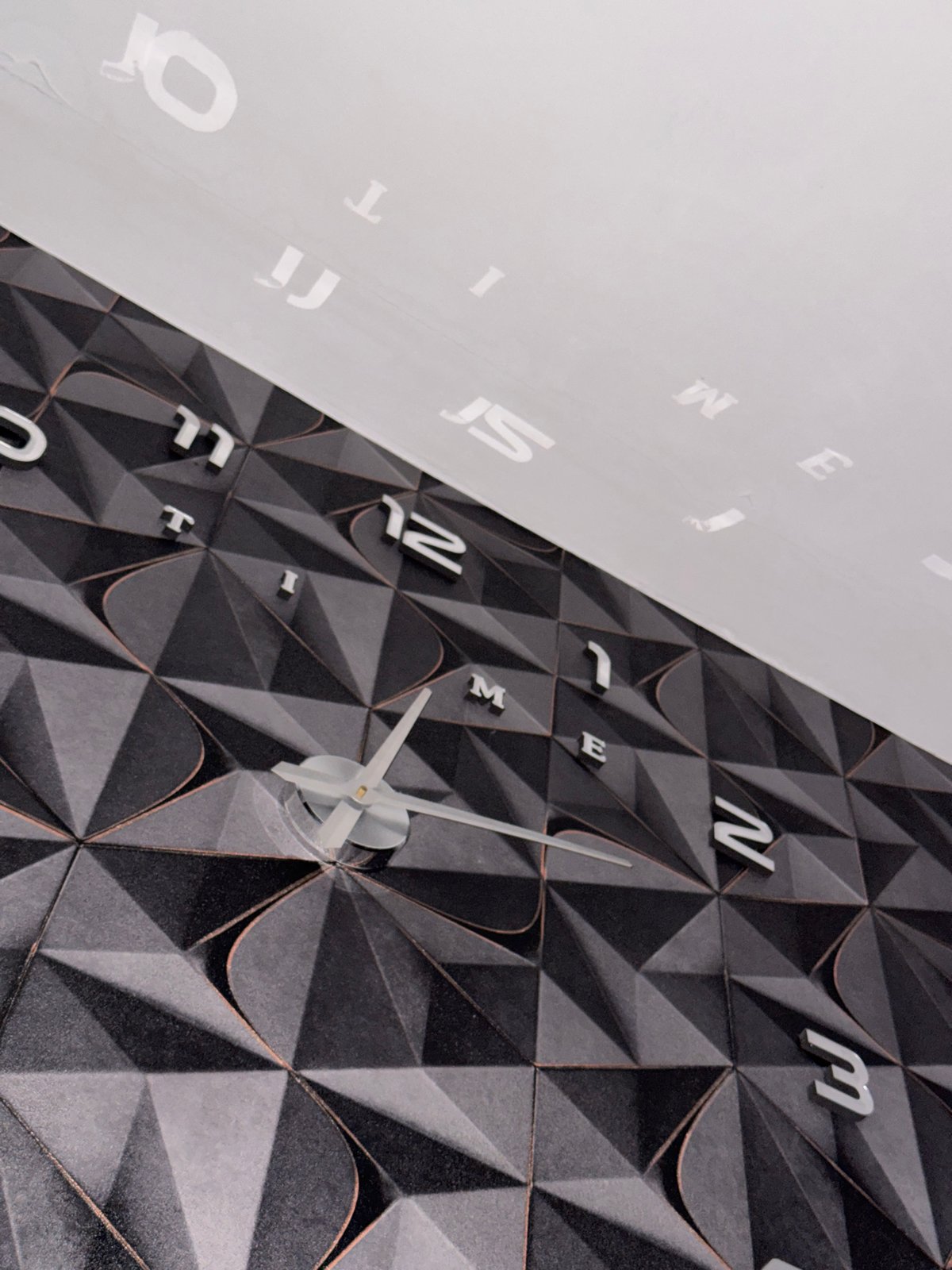Decorative letter-numeral clock observed on patterned wall in Russia