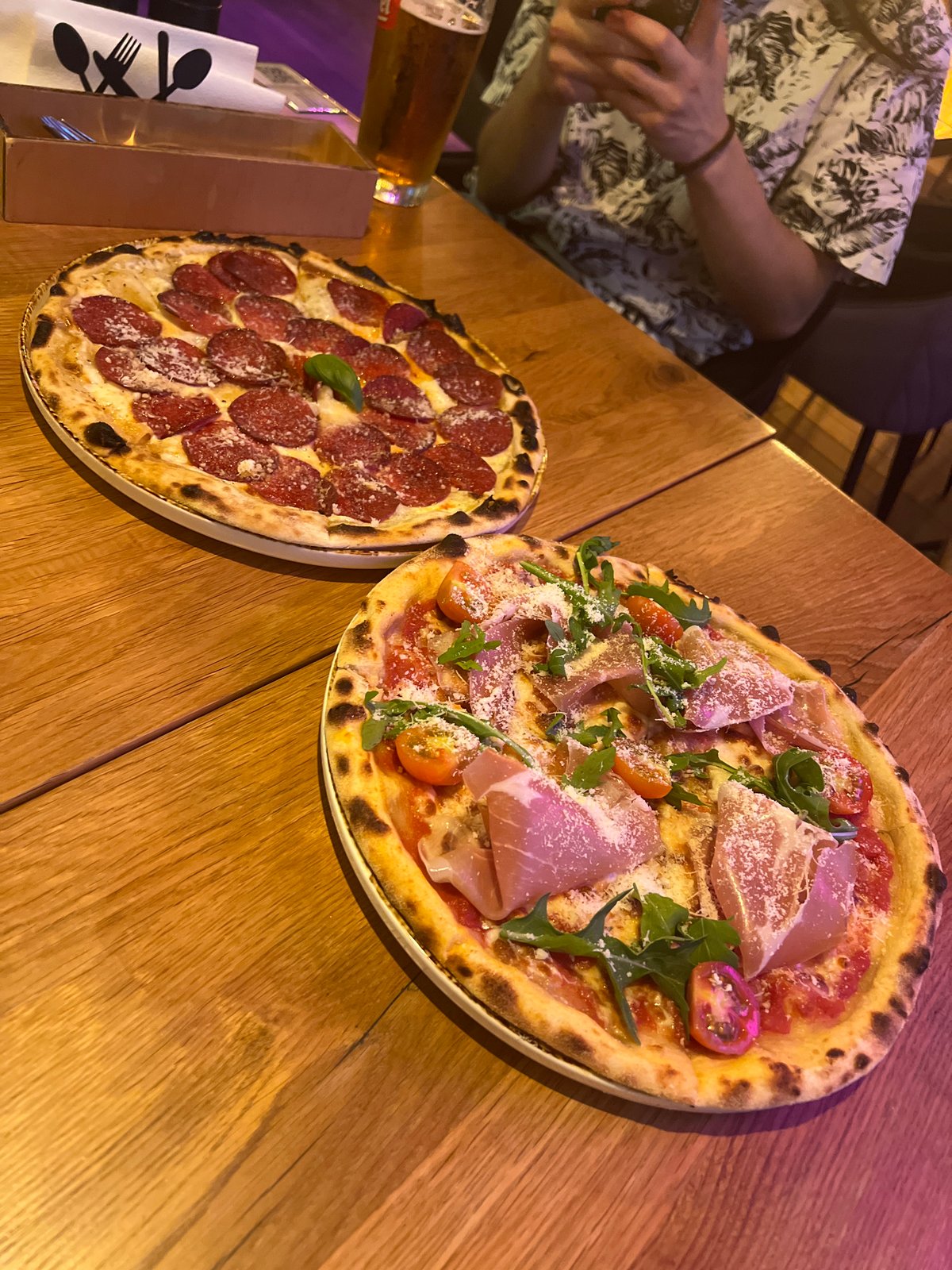 Artisanal pizzas and neon signs at a Krakow restaurant