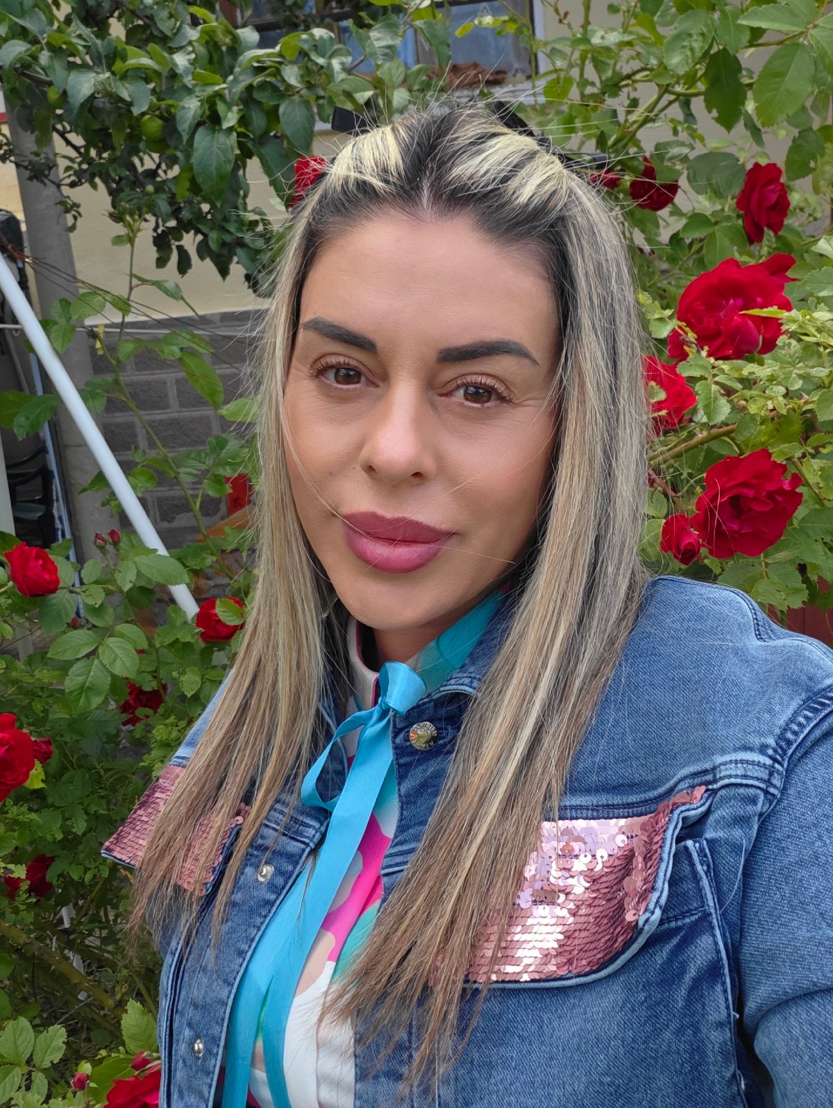 Portrait in front of red roses, Ravnogor, Bulgaria
