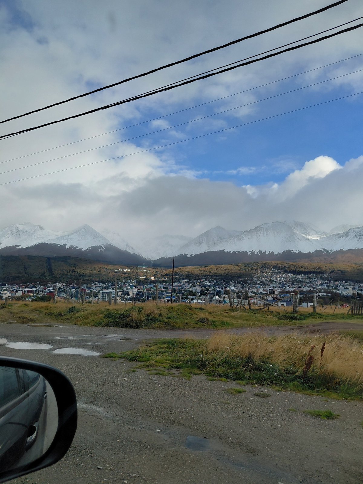 Vehicle travels damp unpaved road in Ushuaia outskirts
