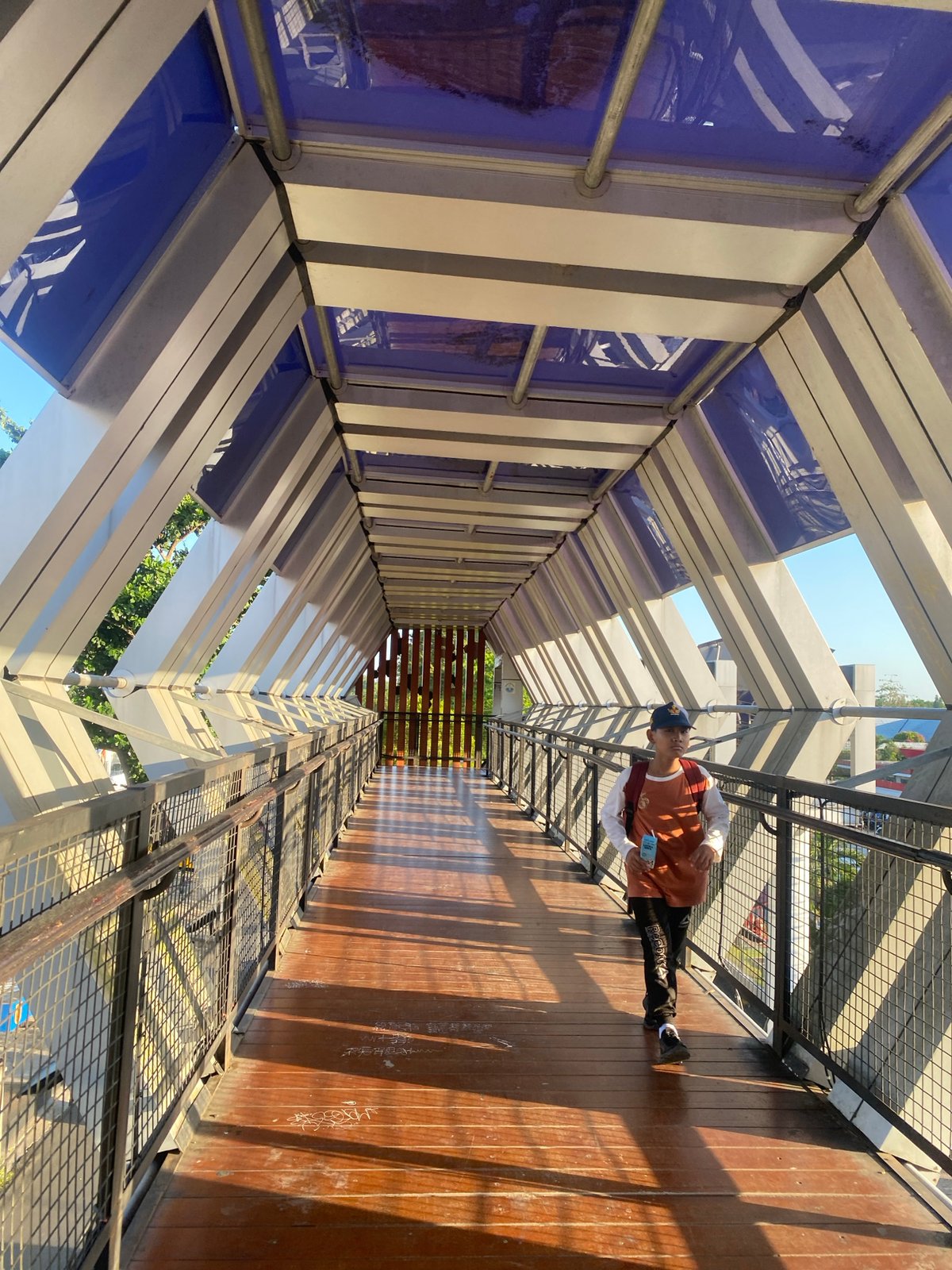 On a pedestrian overpass above busy Banjarbaru streets, Indonesia
