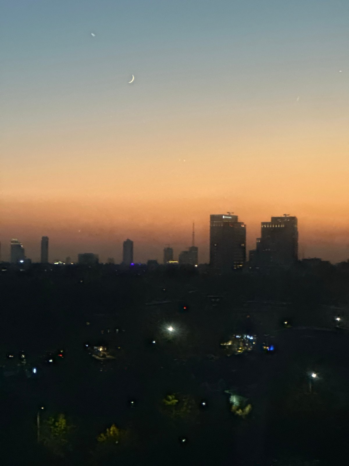 Dusk ride on a Tashkent Ferris wheel, city lights coming on