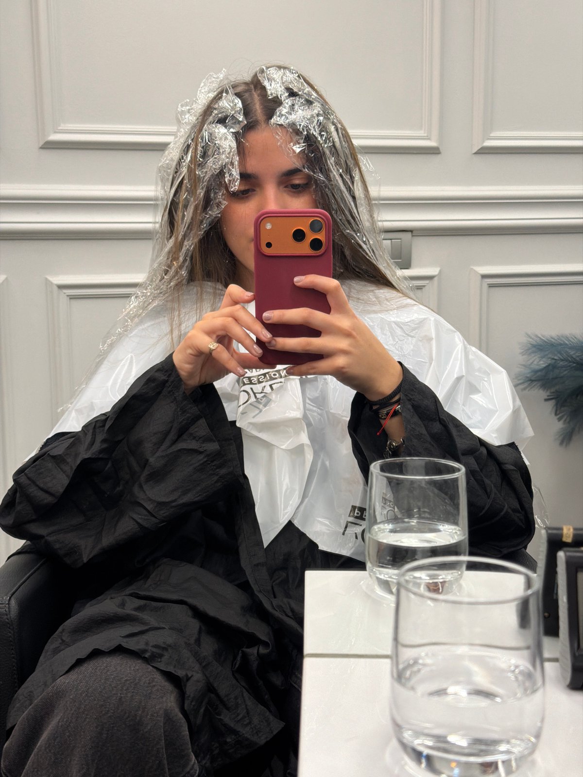 Woman takes mirror selfie during hair treatment in Milan