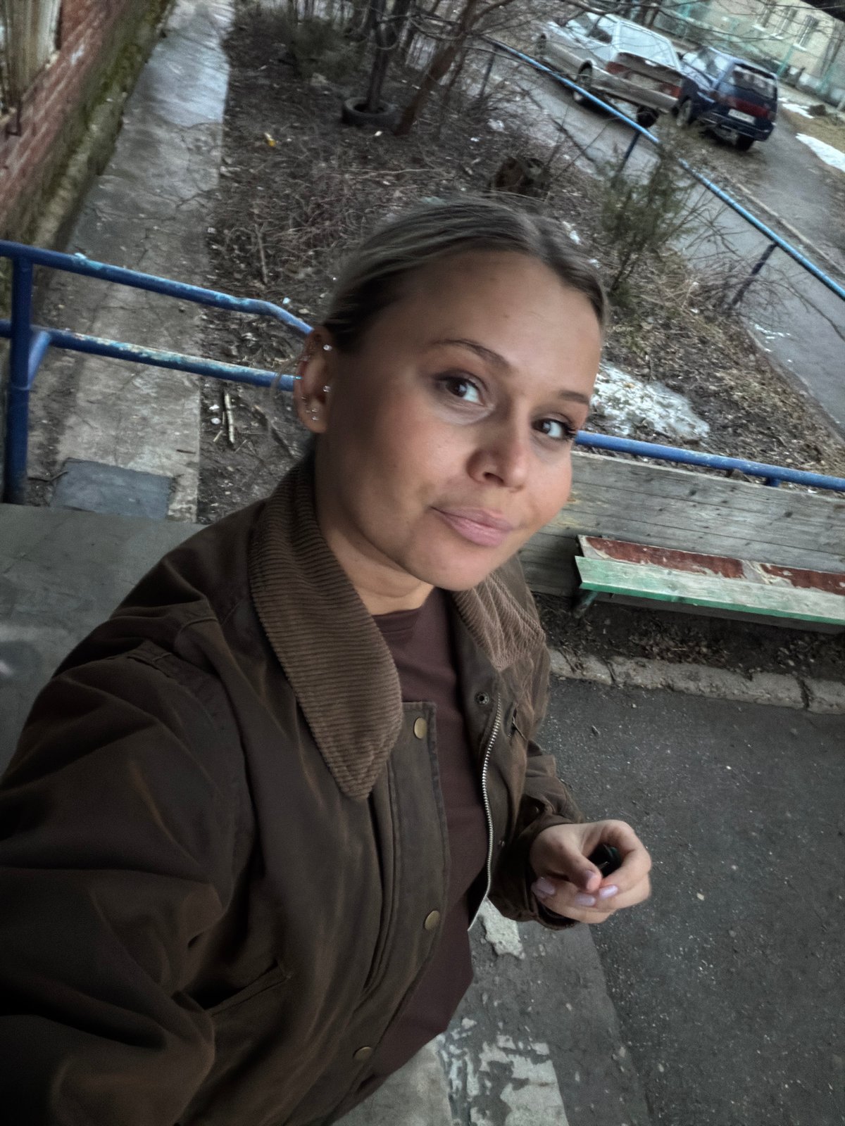 Woman takes selfies around Sarapul, Russia buildings and car