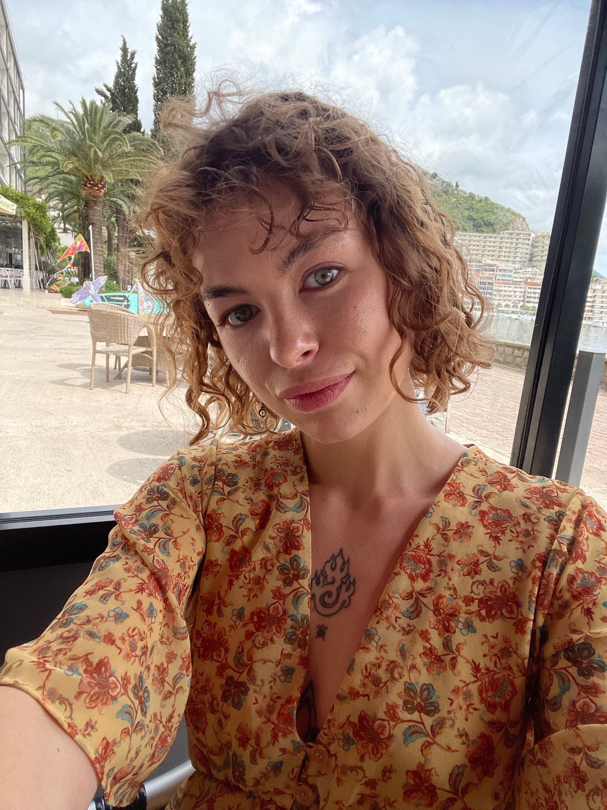 Woman takes selfies in yellow floral dress in Rafailovići