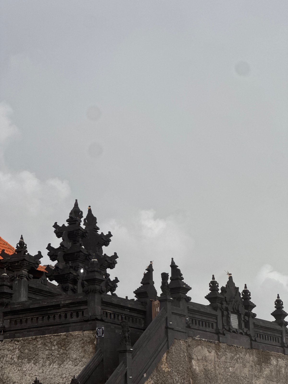 Traditional Balinese temple gate observed under grey skies