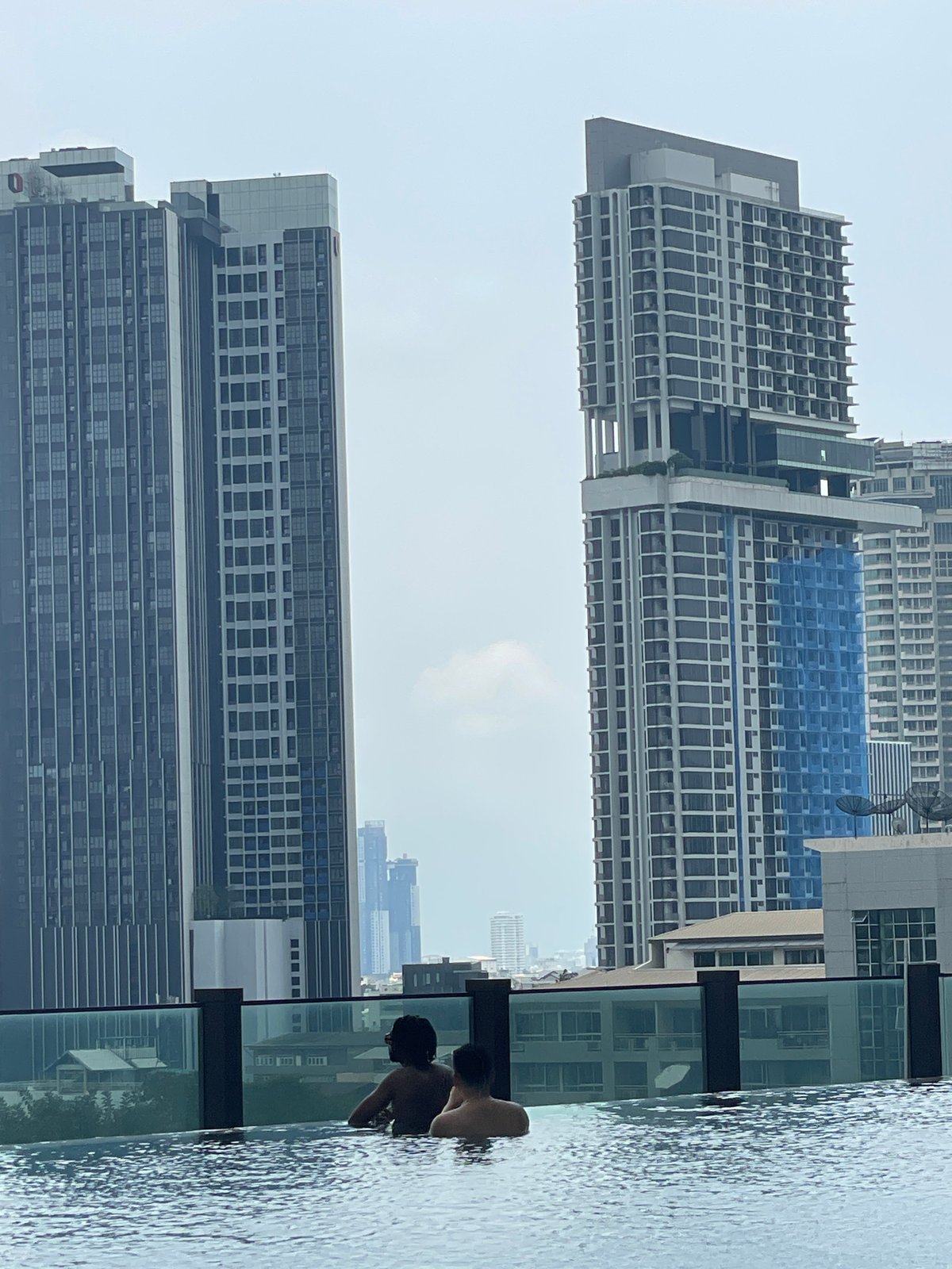 Early morning rooftop pool relaxation captured in Bangkok skyline