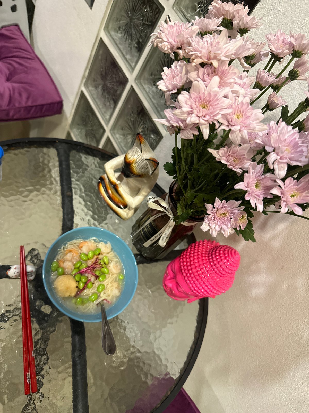 Pink flowers and Buddha statue arranged on Ko Samui table