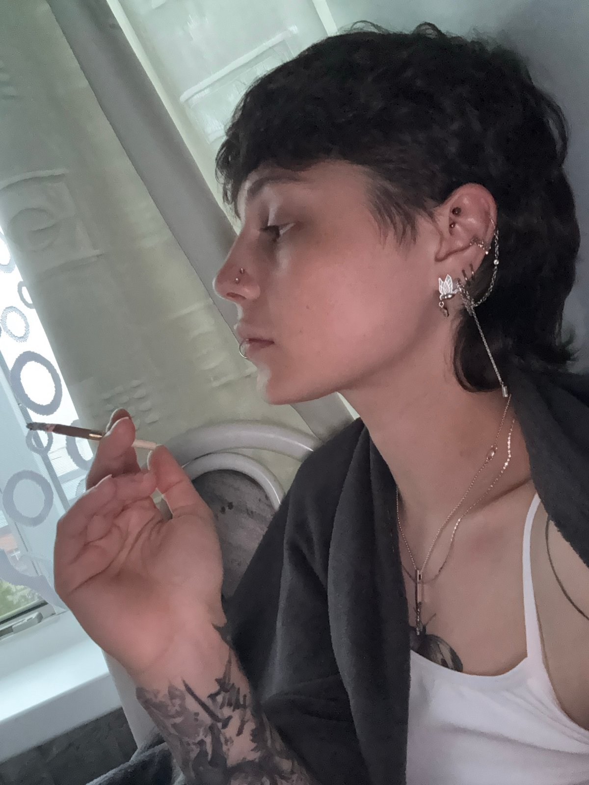 Pierced individual with mullet spotted smoking indoors in Saint Petersburg