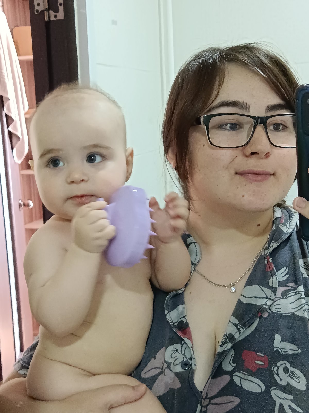 Woman holds teething baby with purple toy, later resting