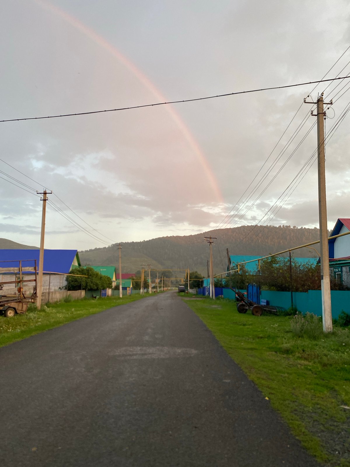 Post-rain summer evening with kids and a rainbow in rural Russia