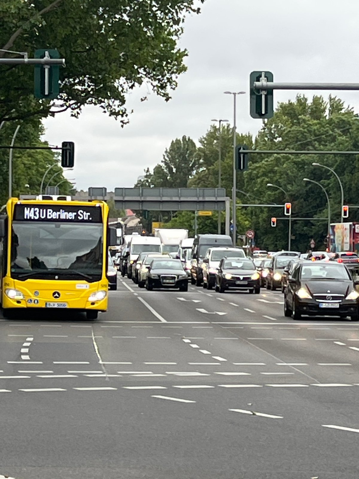 Berlin intersection activity with yellow buses and street life