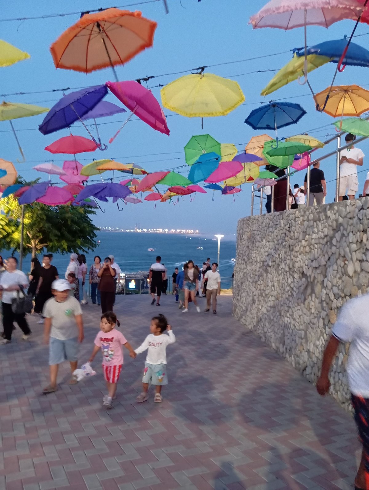 Aktau's umbrella-lined Caspian promenade at dusk