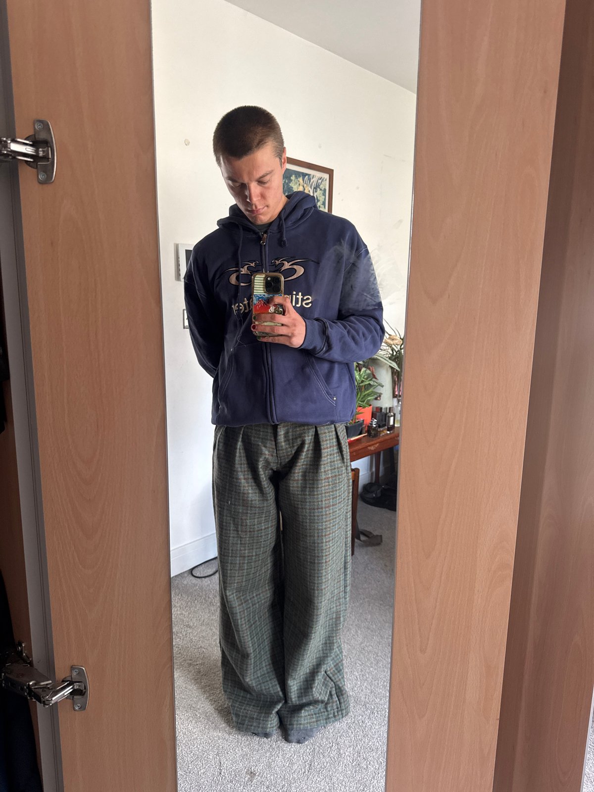 Person checks phone in mirror, central London morning