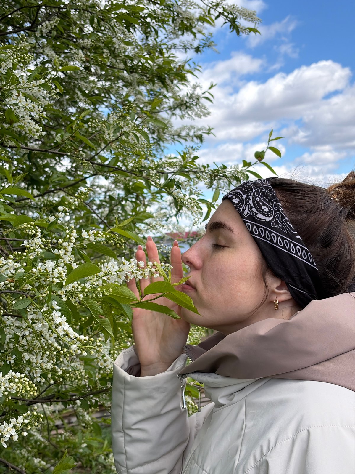 Woman enjoys spring flowers amid rural life in Russian village