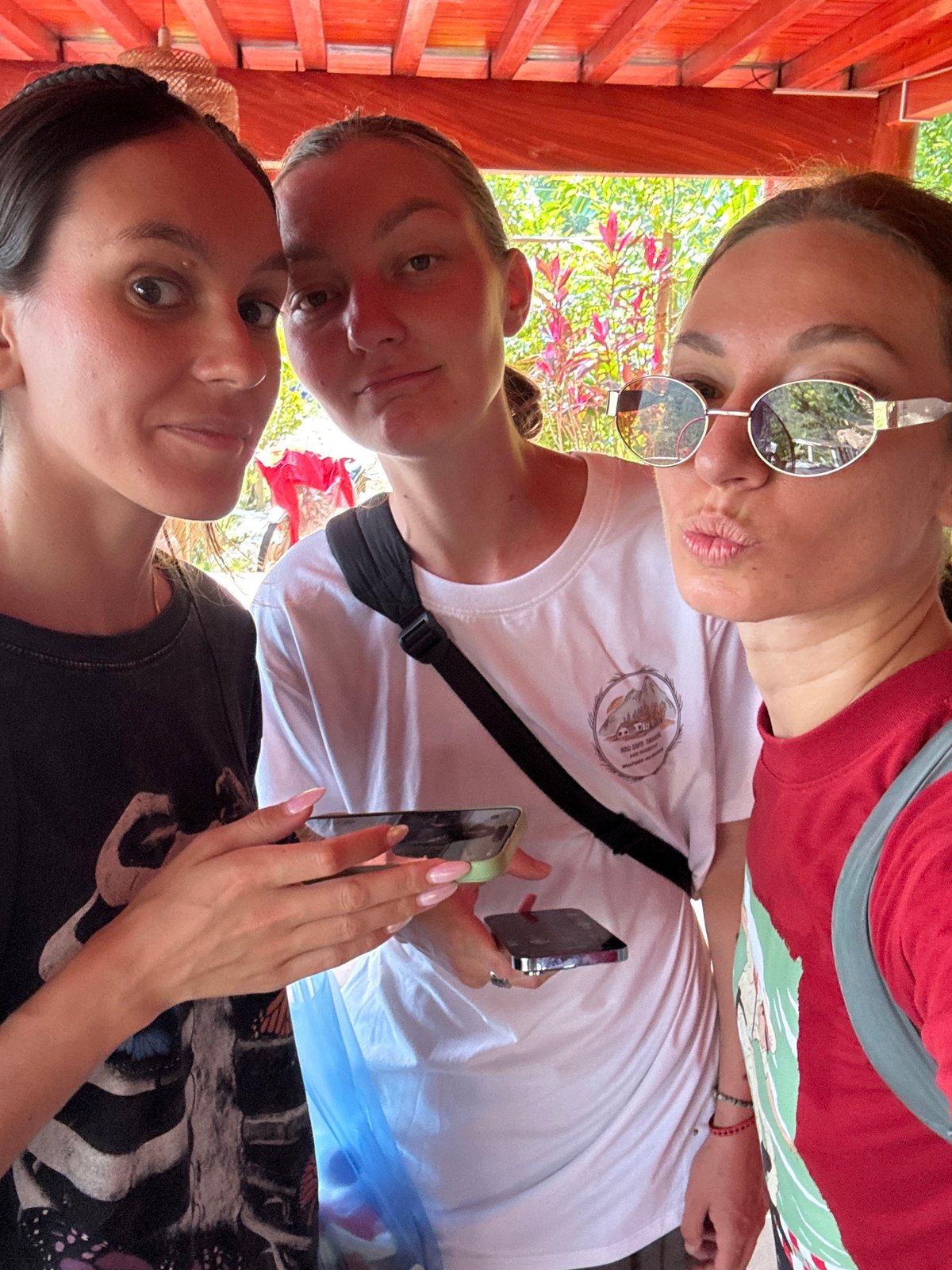 Three women take selfies in Vietnamese commune