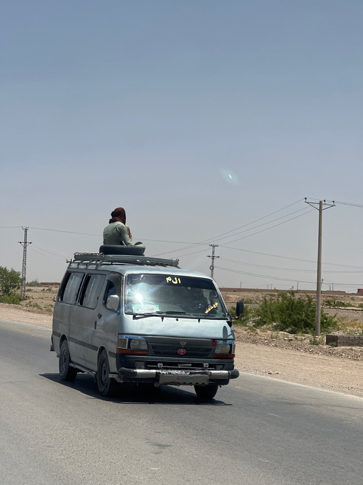Van travels road in Yaru Karez under hazy morning sky