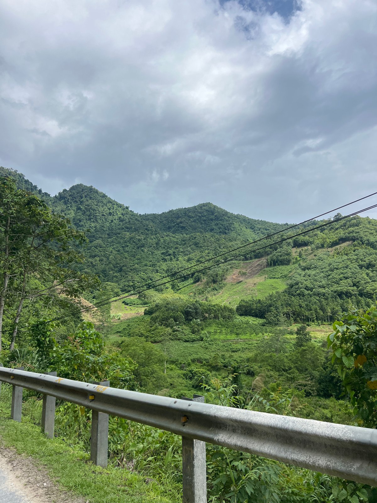 Mountain road winds through forested hills of Minh Tân Commune