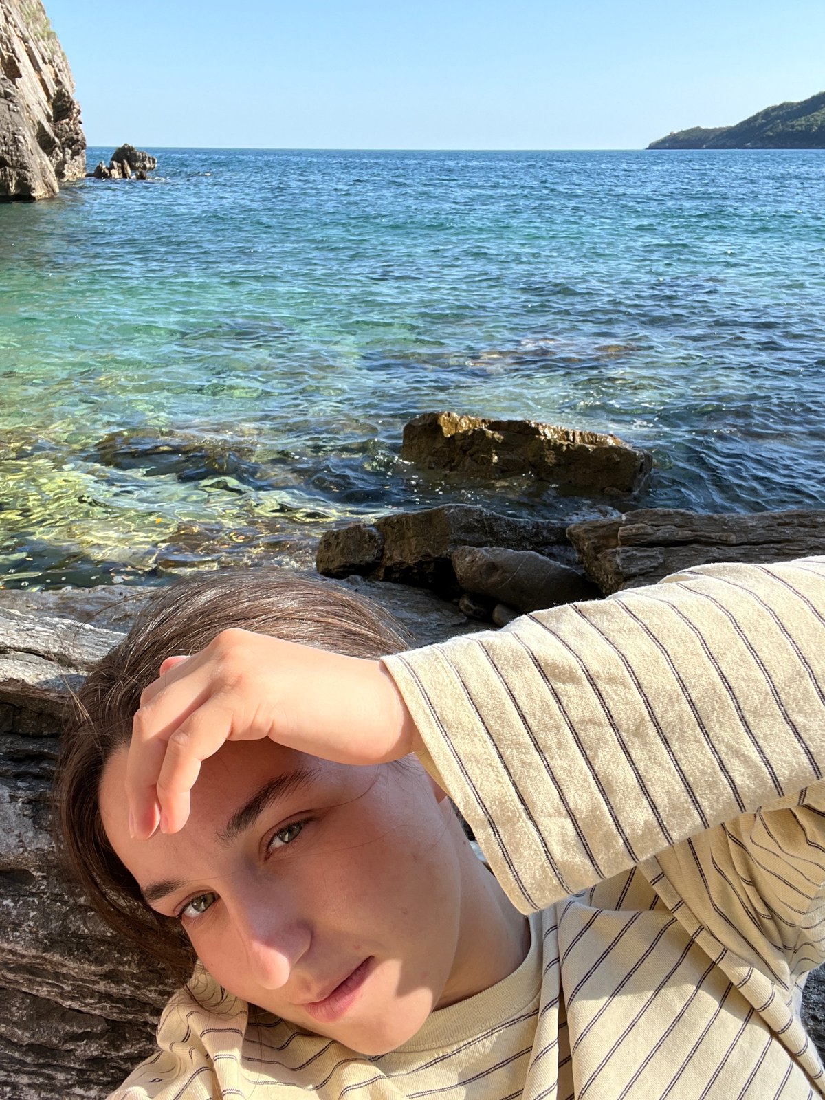 Woman relaxes on rocky coastline in Budva, Montenegro