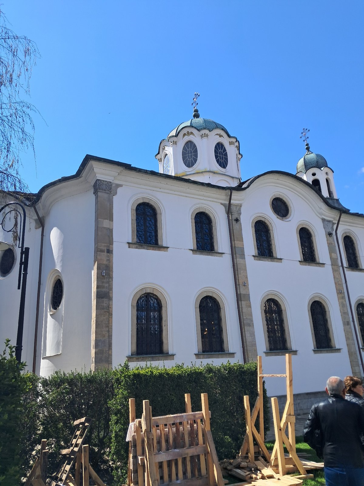 White domed building observed amid construction materials and foliage