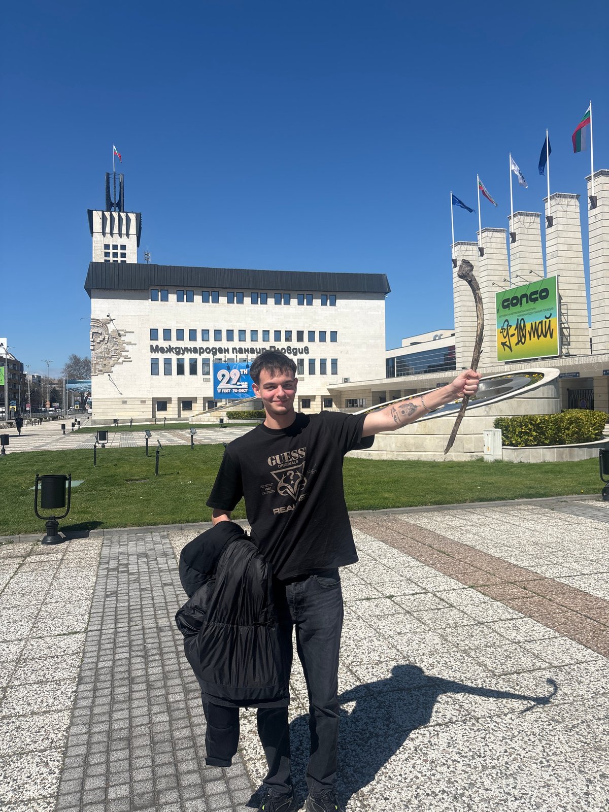 Man holds branch outside Plovdiv International Fair building