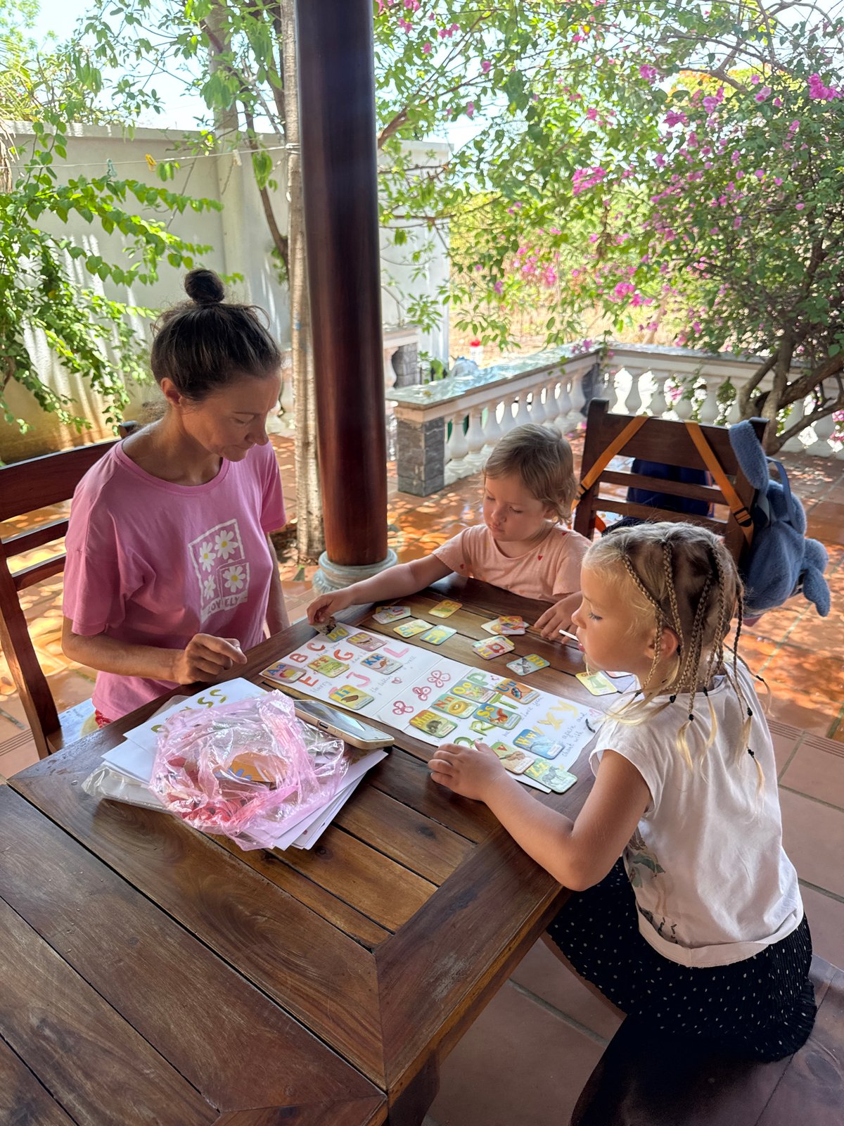 Woman, children play card games on patio in Vietnam