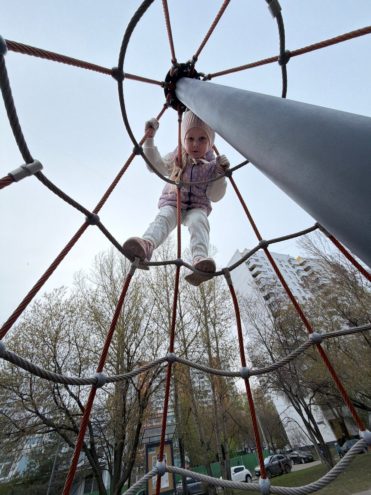 Child plays on rope climbing structure at Moscow playground