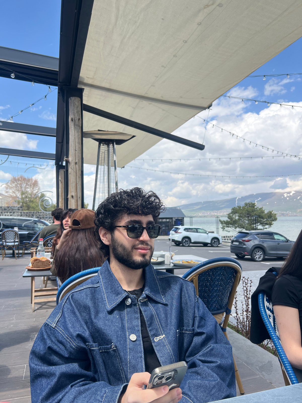 Man dines at outdoor cafe while using smartphone