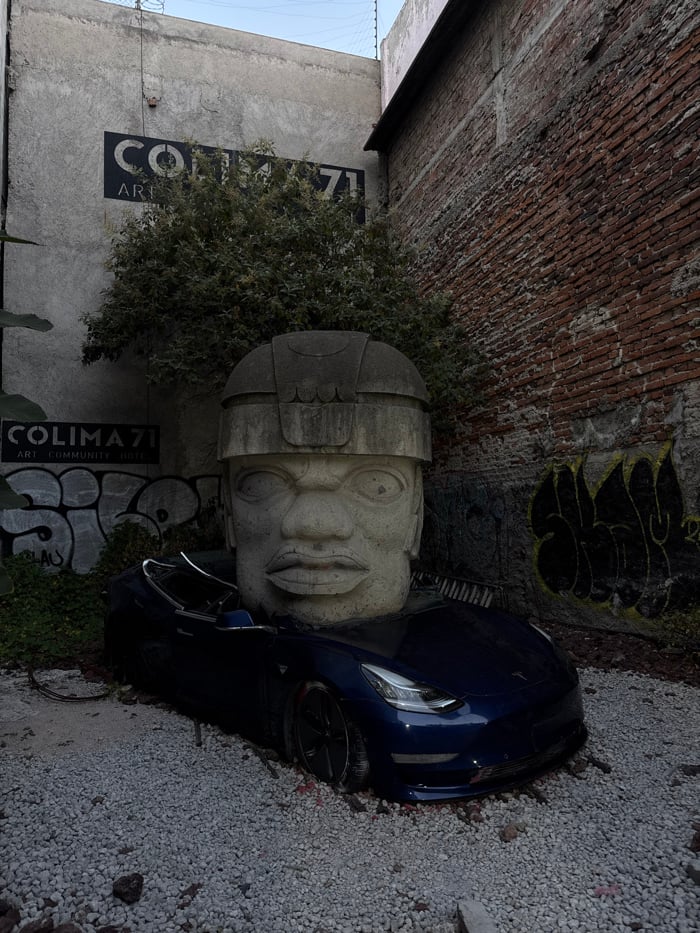 Blue Tesla meets ancient Olmec sculpture in Mexico City street art scene