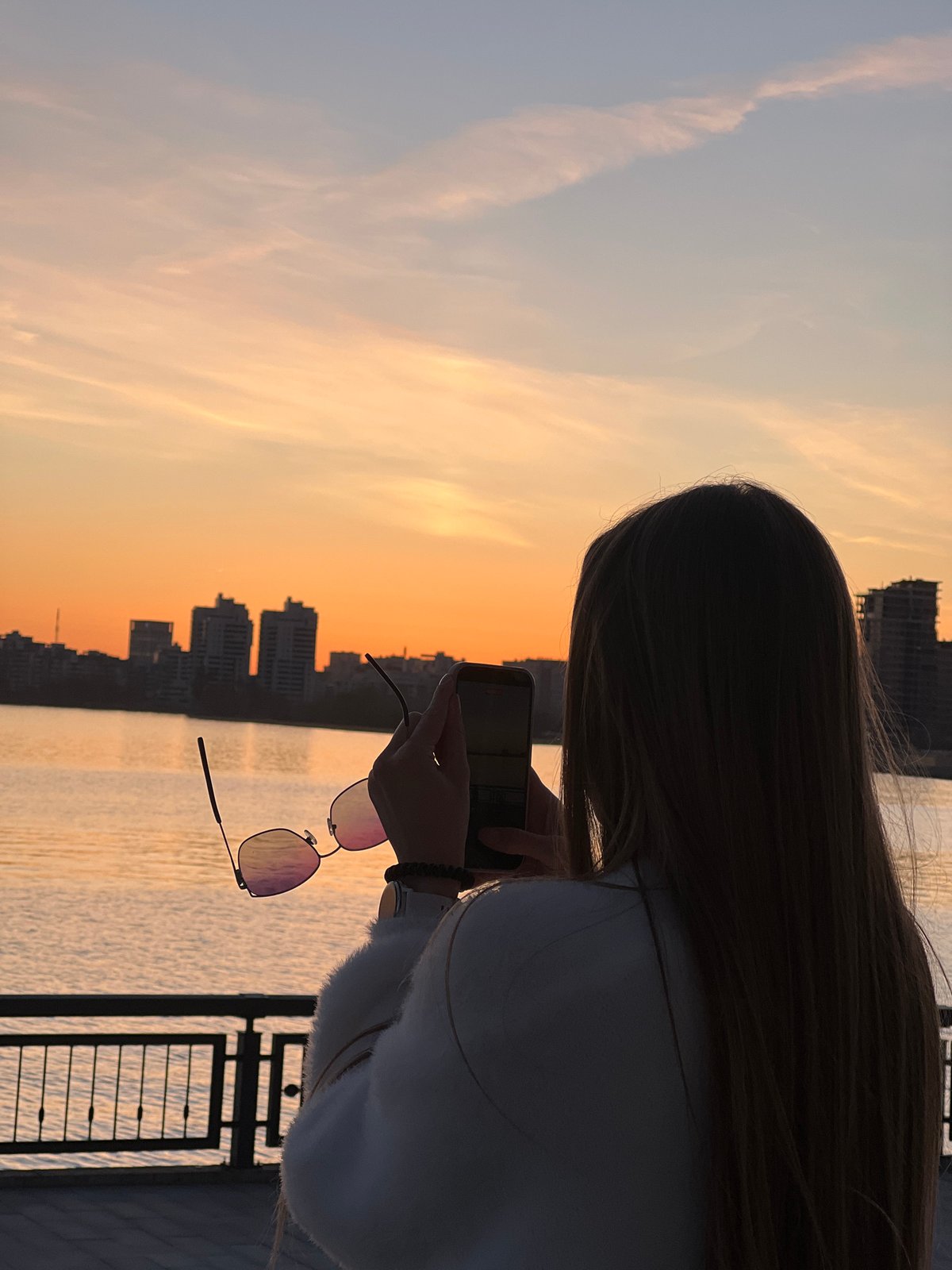 Woman watches sunset from Kazan waterfront promenade