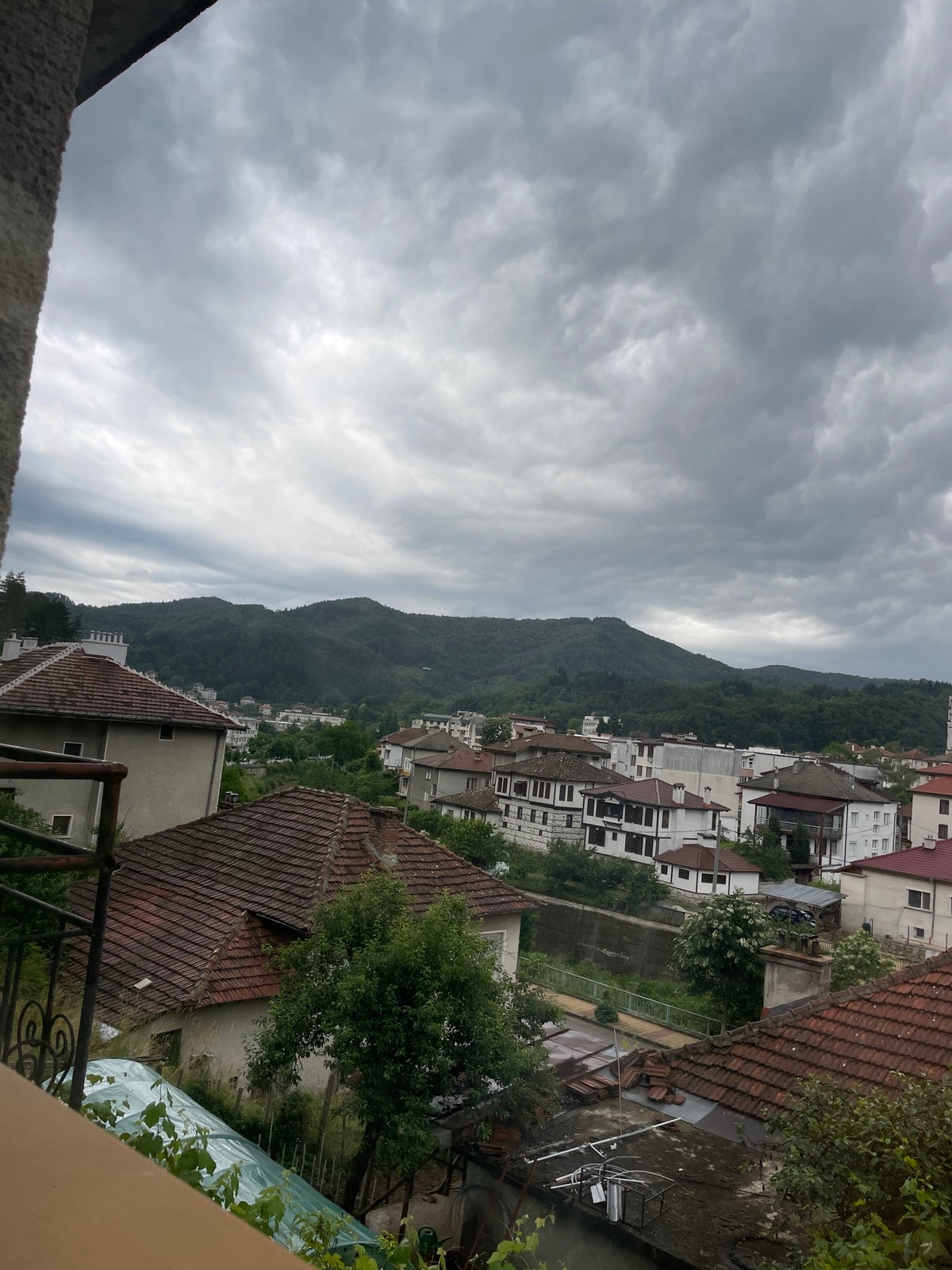 Dramatic clouds captured over Bulgarian mountain town from balcony