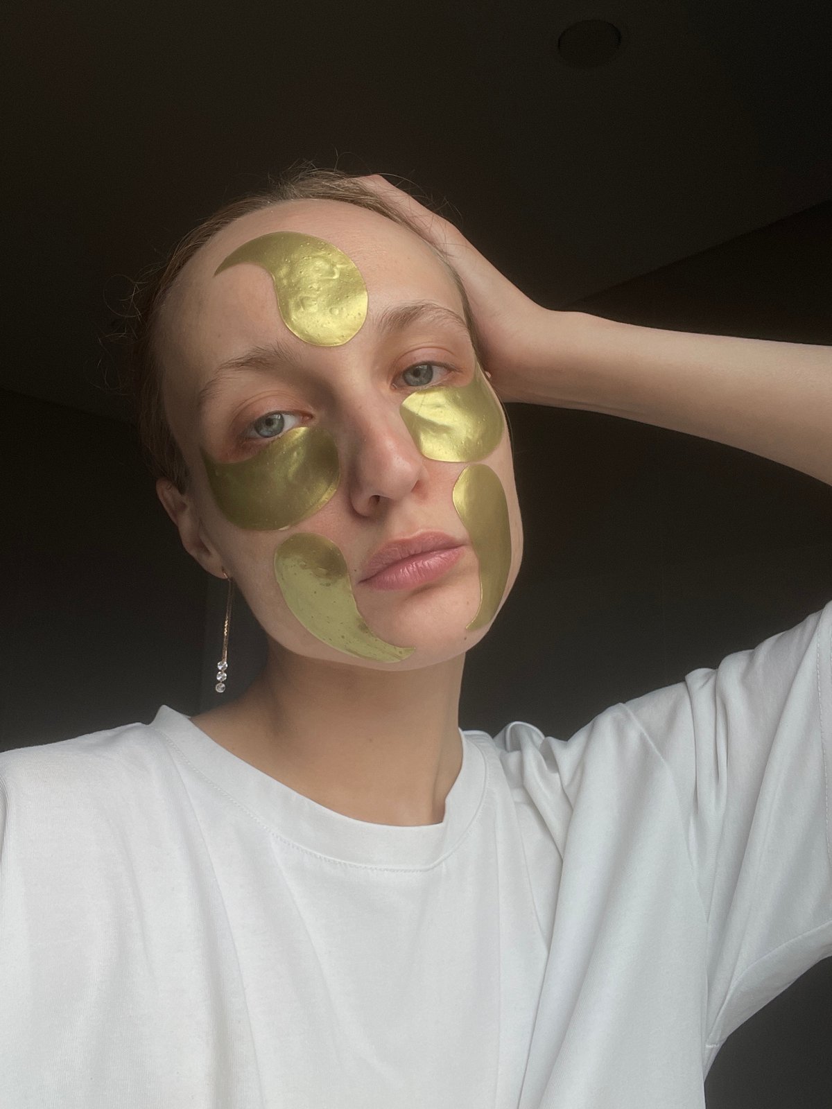 Woman takes bathroom selfies wearing gold facial patches