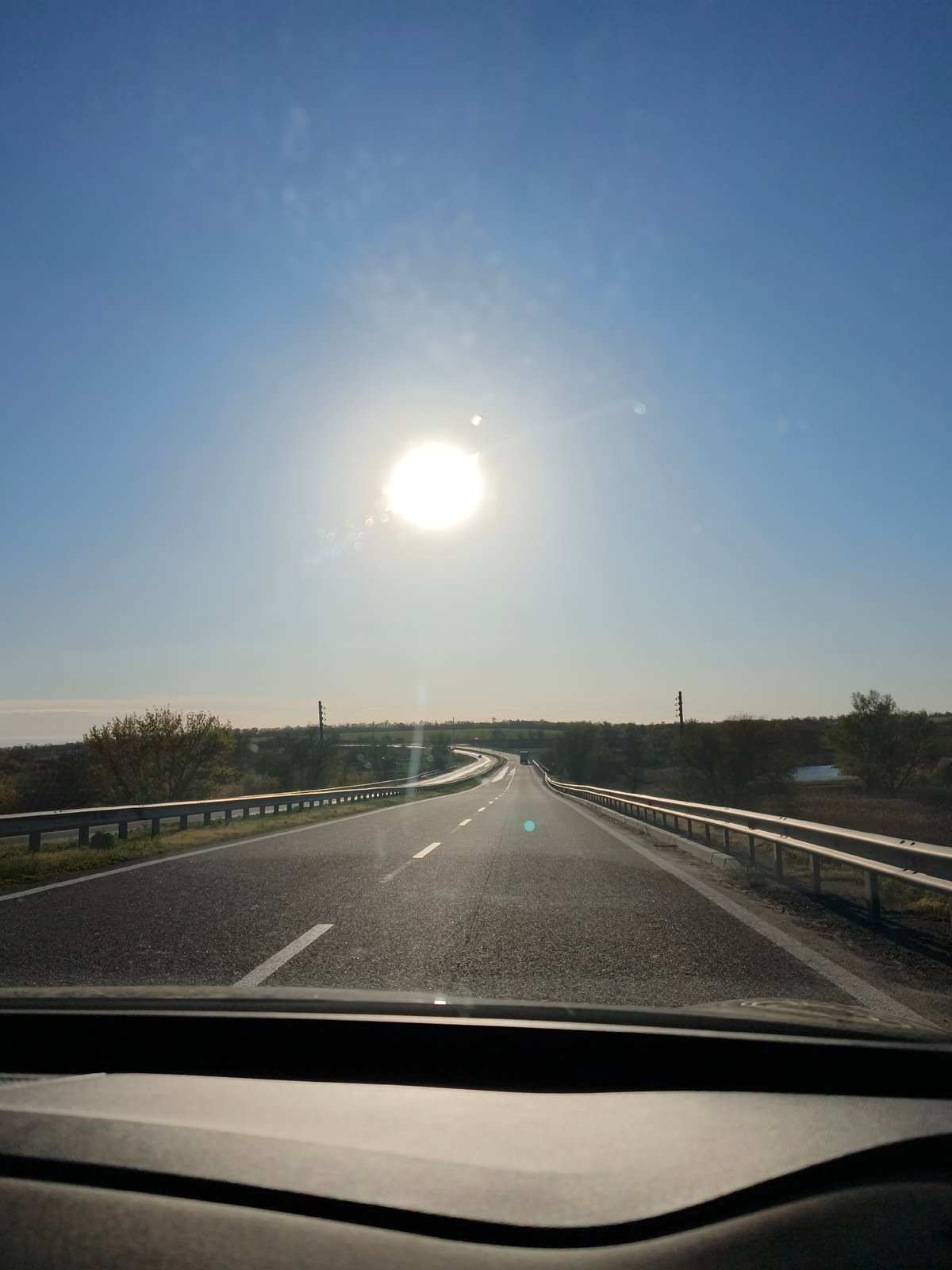 Two people drive through Malosofiivka under clear morning skies