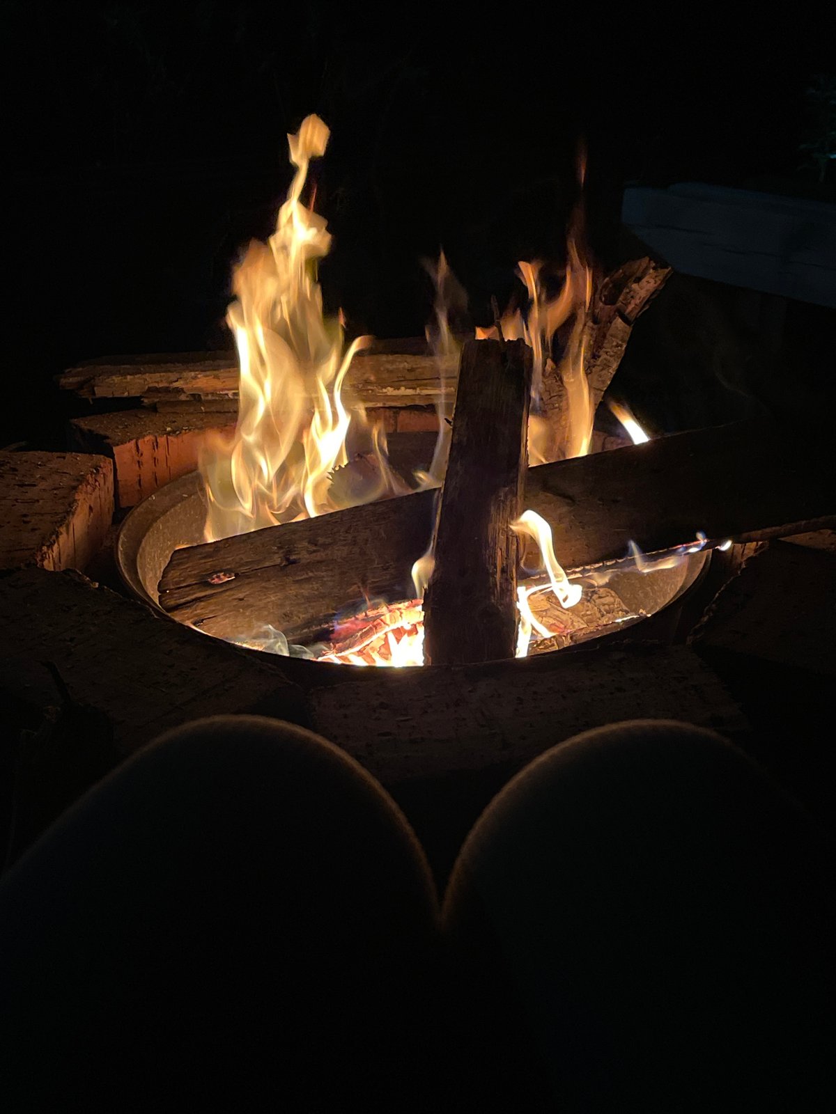 Evening campfire burning in a backyard brick fire pit