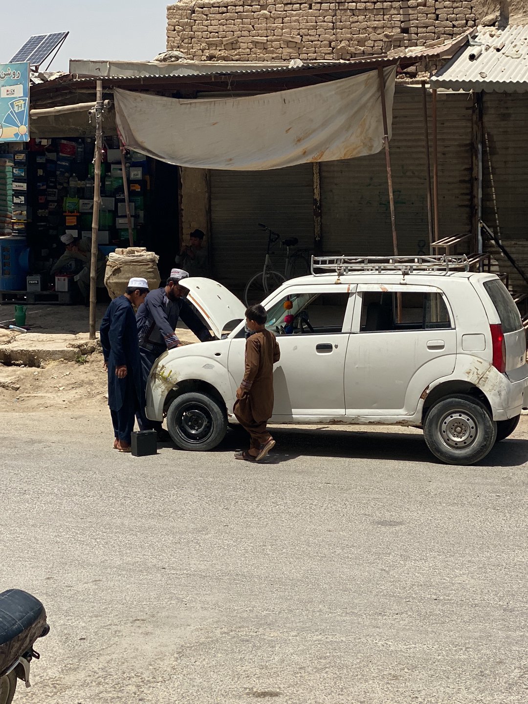 Daytime street scene documented outside Kandahar shop