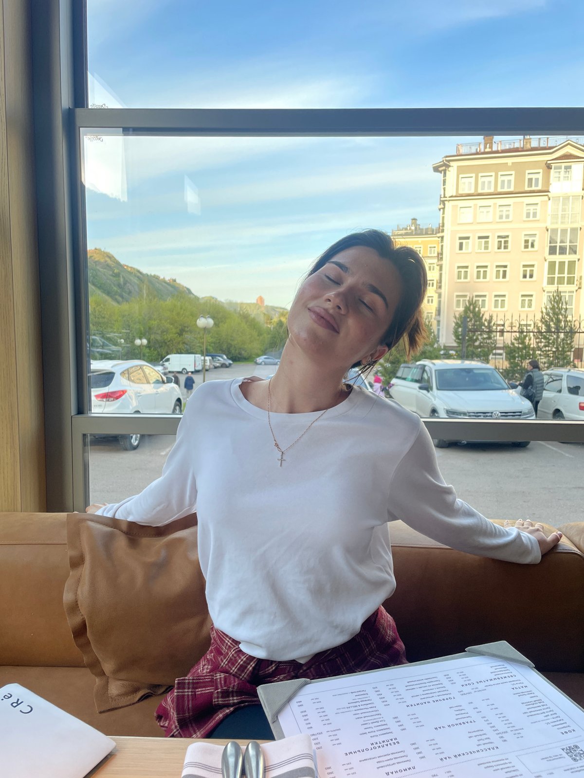 Woman dines alone at restaurant window in Krasnoyarsk