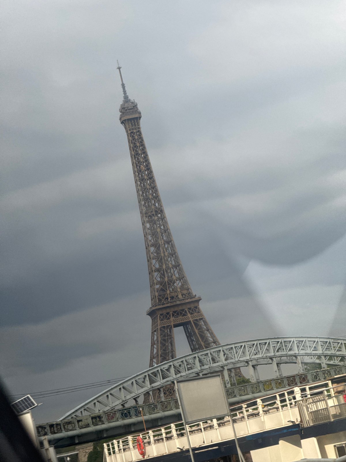 Paris landmarks viewed from moving vehicle under cloudy skies