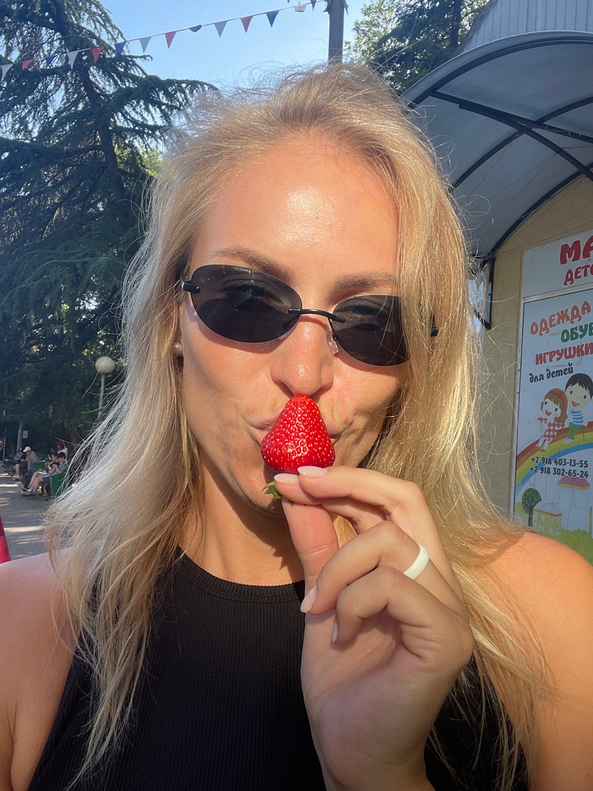 Woman enjoys strawberries, sightseeing during afternoon in sunny Sochi