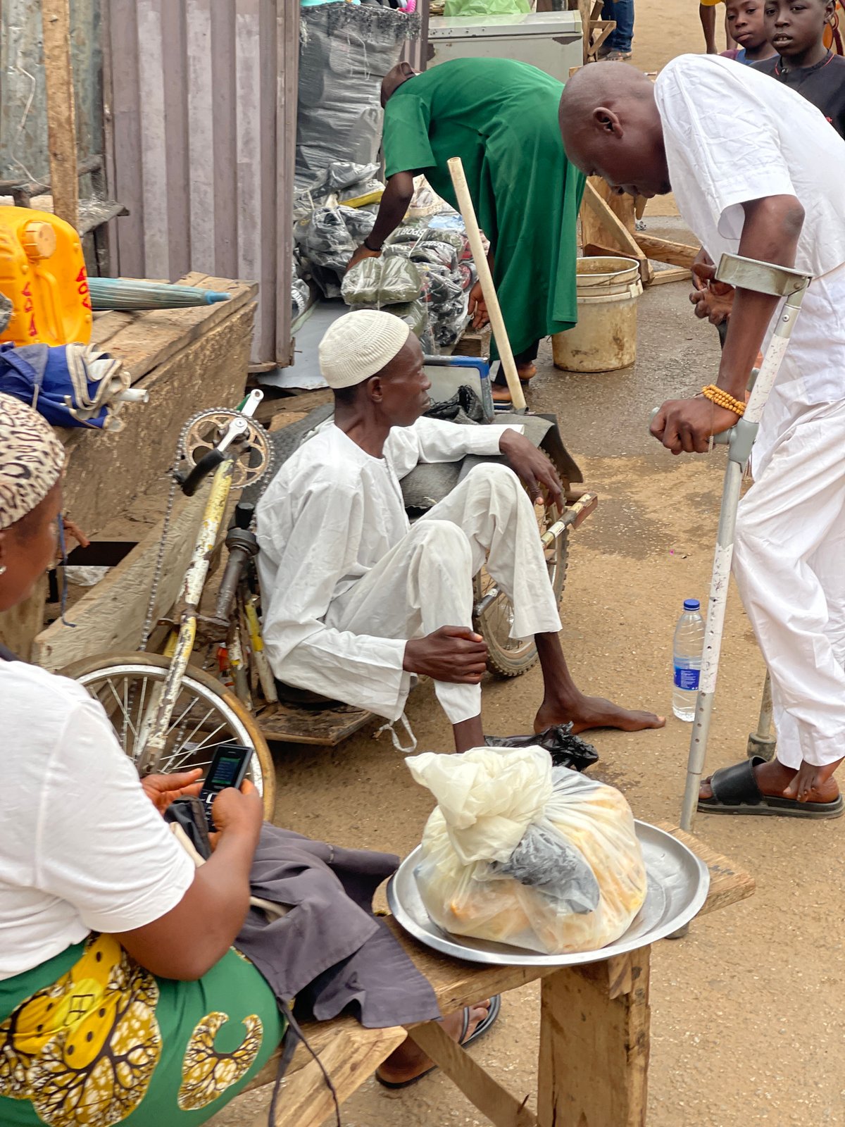 Person rests among bicycle parts in Kuchingoro, Nigeria