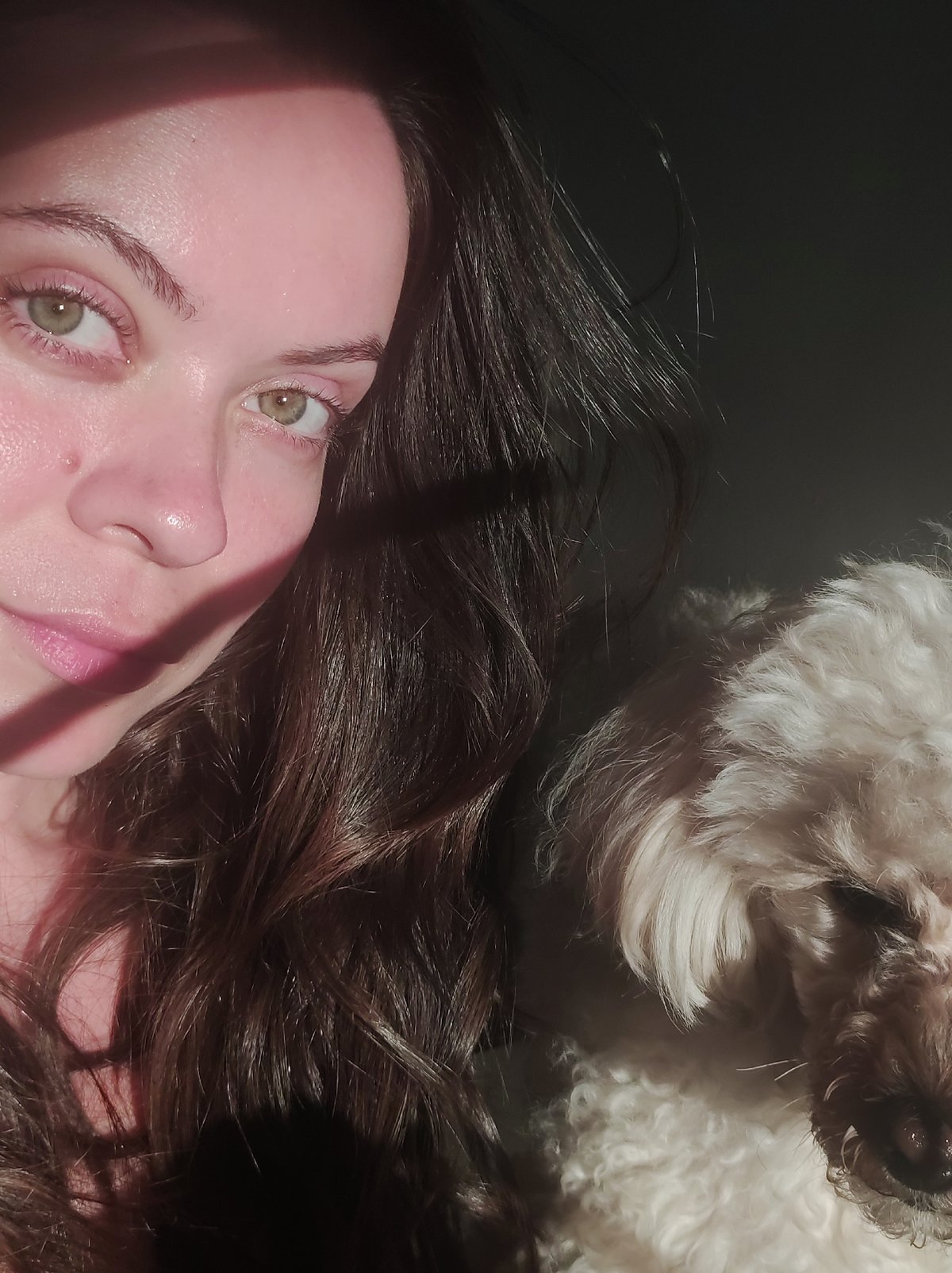 Woman takes selfie with dog in sunlit photograph