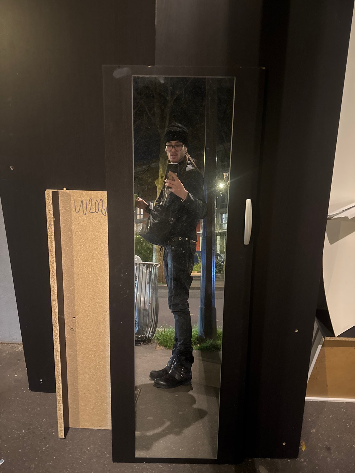 Person in black attire reflected in Paris wardrobe mirror