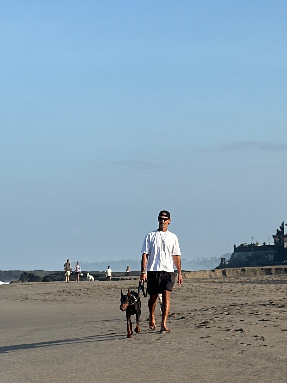 Golden hour on North Kuta beach: people, dogs, and surf.