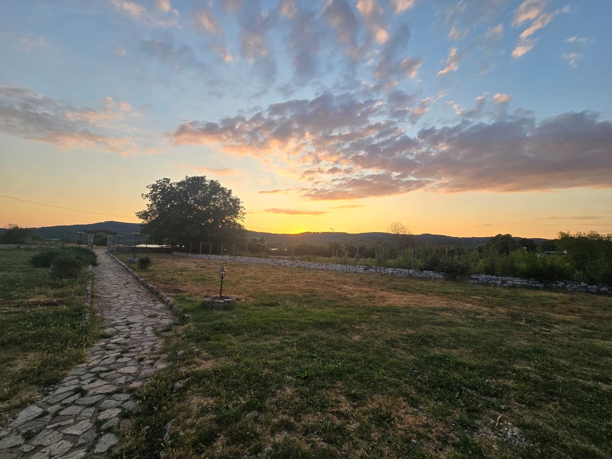 Sunset over a rural stone-path property in Malko Tarnovo, Bulgaria