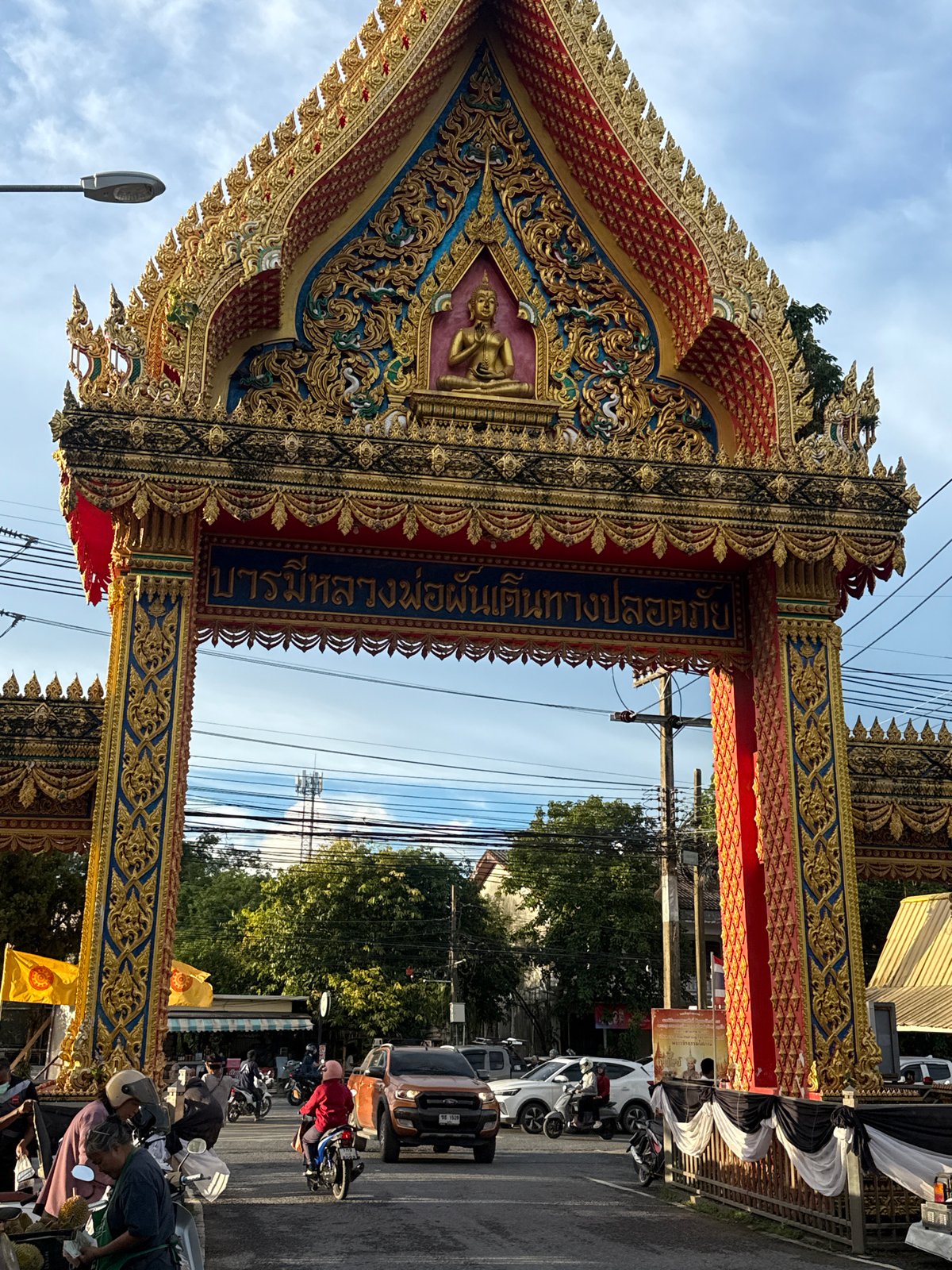 Ornate Buddhist gateway and street life in Si Sunthon