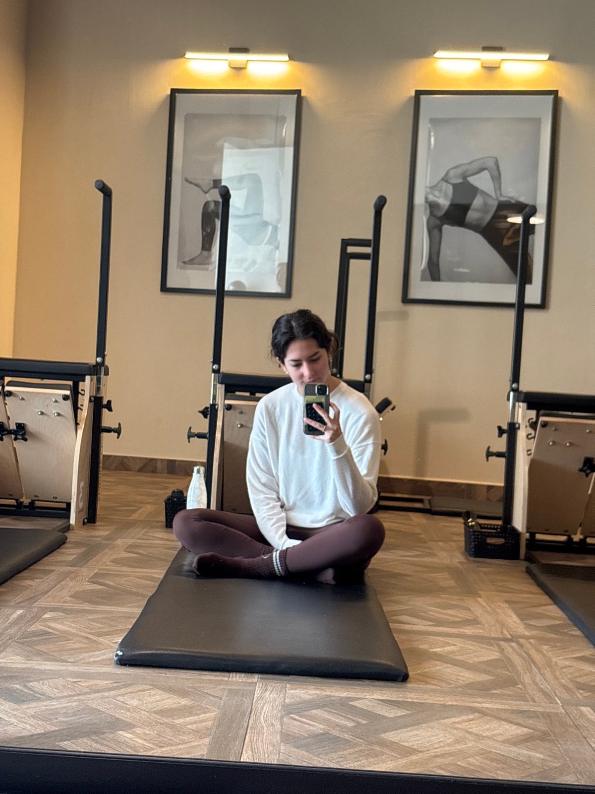 Woman takes selfie on pilates equipment in Mexican fitness studio