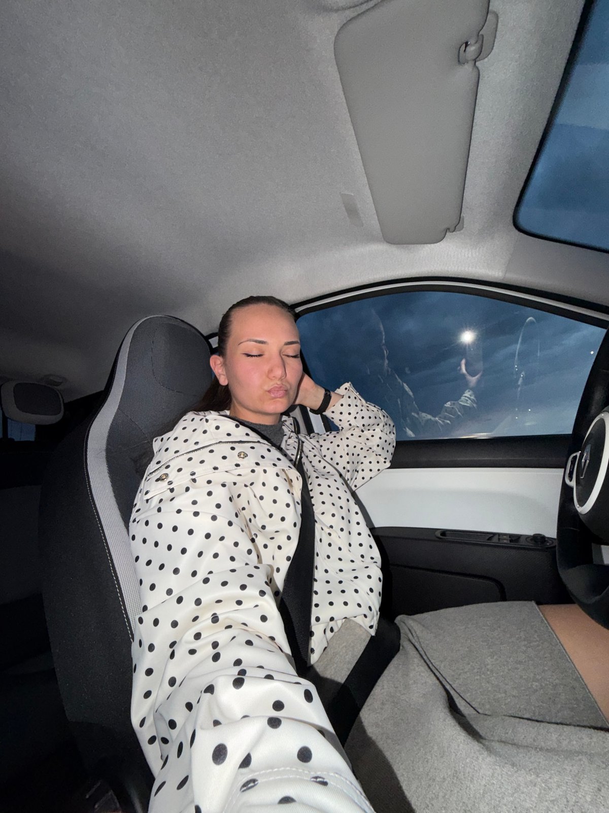 Woman rests in passenger seat during evening in Sofia