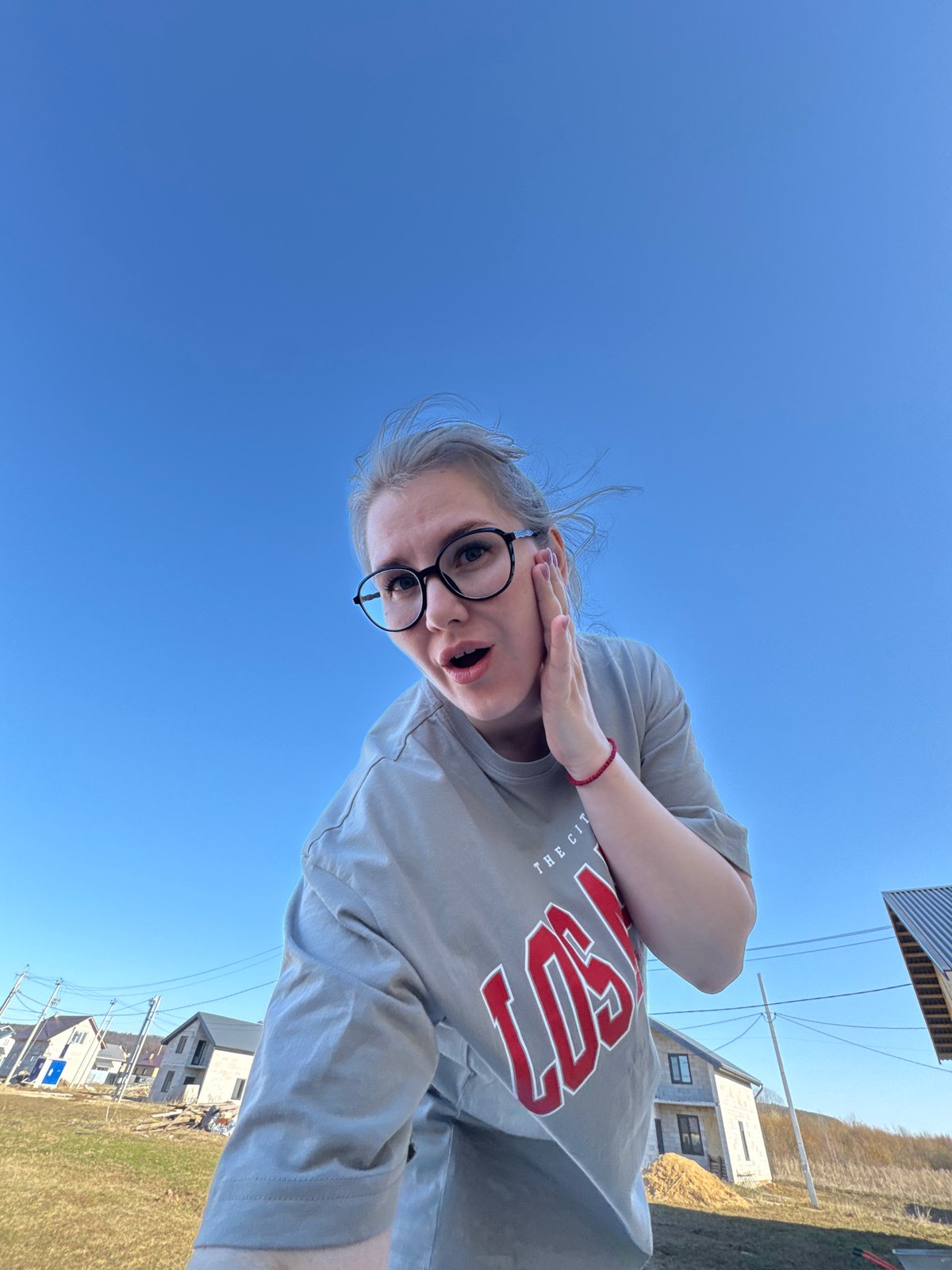 Woman photographs against blue sky in rural Russia