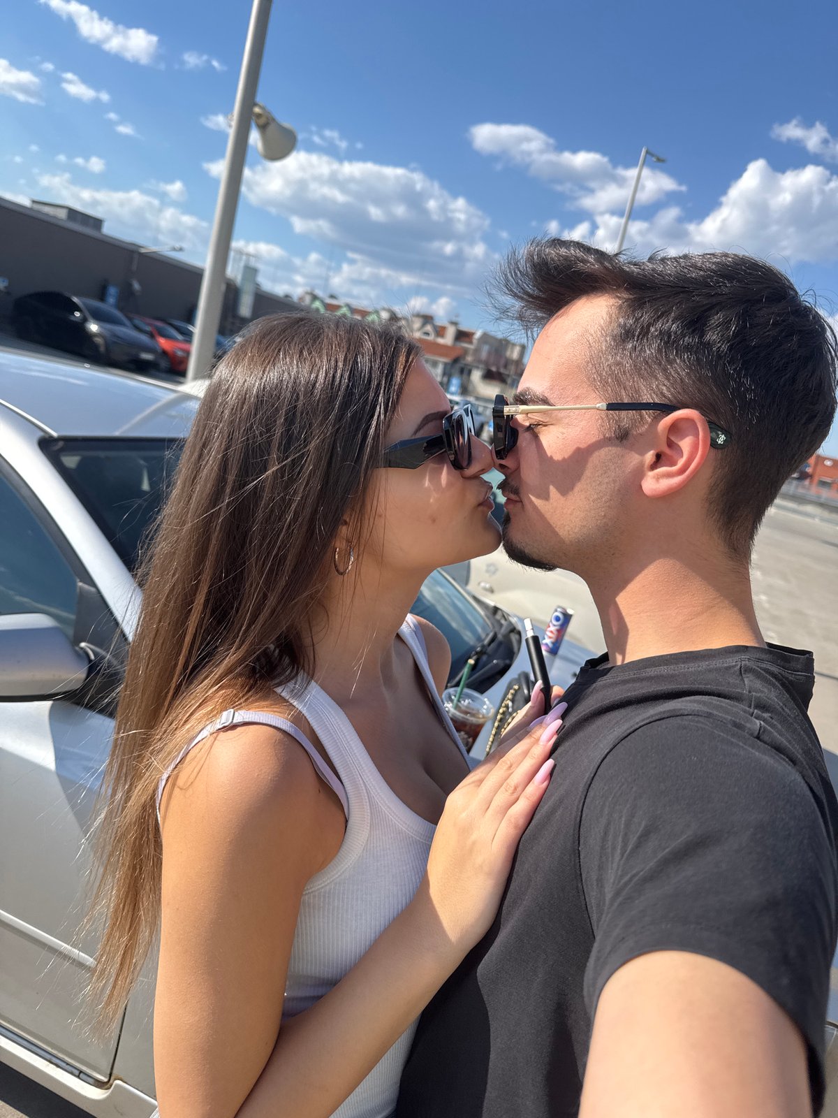 Couple photographed kissing, embracing around Sofia parking lot, escalator