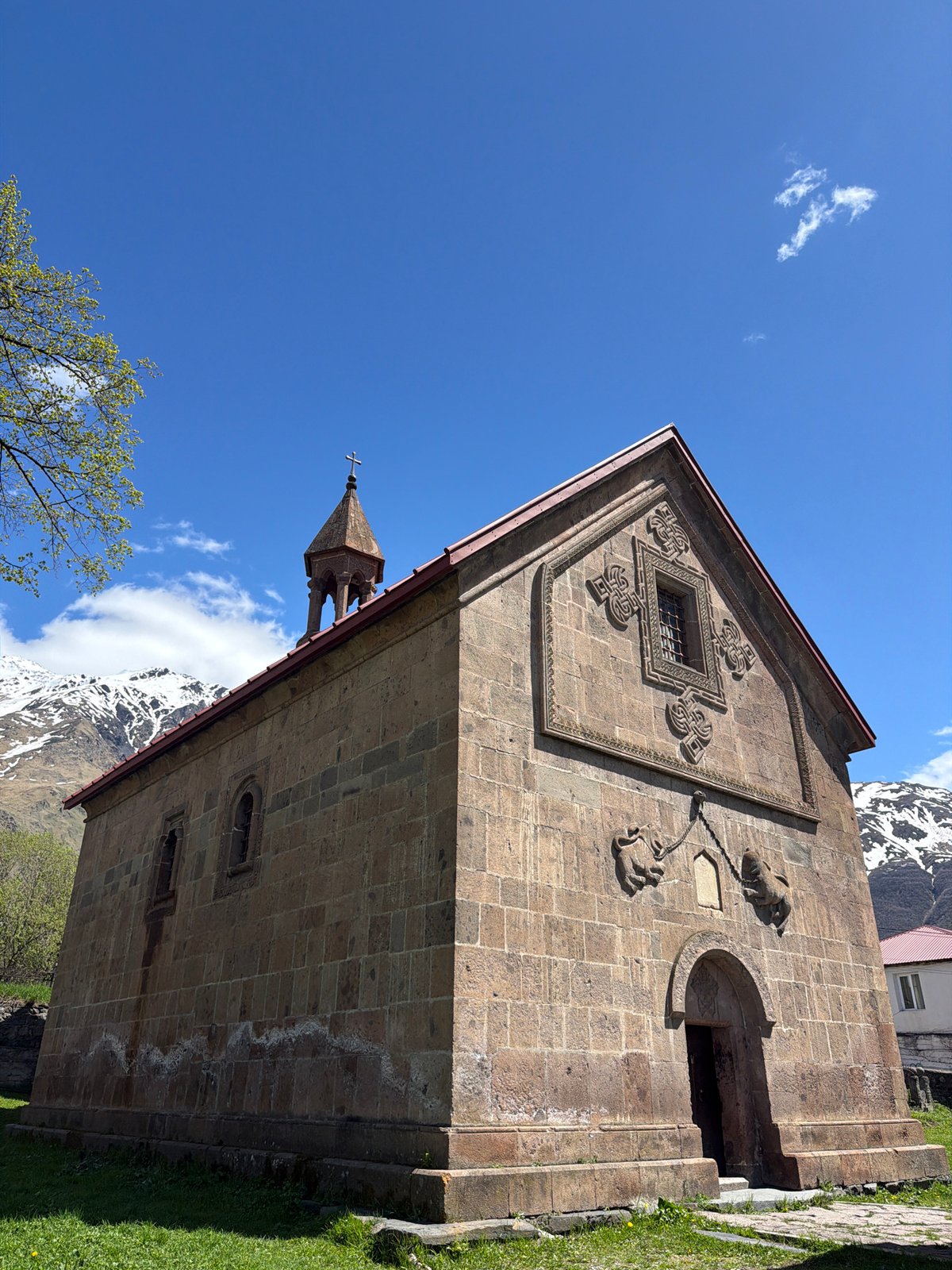 Tourist documents historic church and mountains in Stepantsminda, Georgia